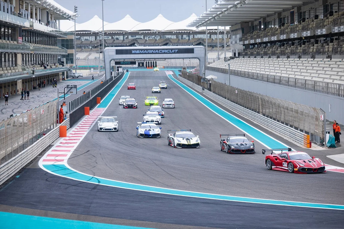Race cars entering the main straight at Yas Marina Circuit in Abu Dhabi.