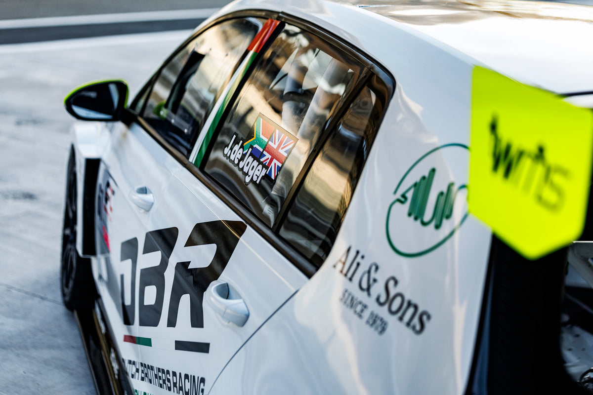 Close-up of the Dutch Brothers Racing Golf's rear quarter, showing the DBR logo, the Ali and Sons roundel and the de Jager name decal on the window.