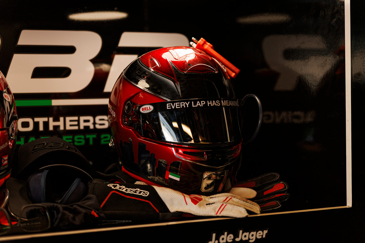 Jon de Jager's red helmet and gloves displayed against the Dutch Brothers Racing backdrop, his name on the plinth below.
