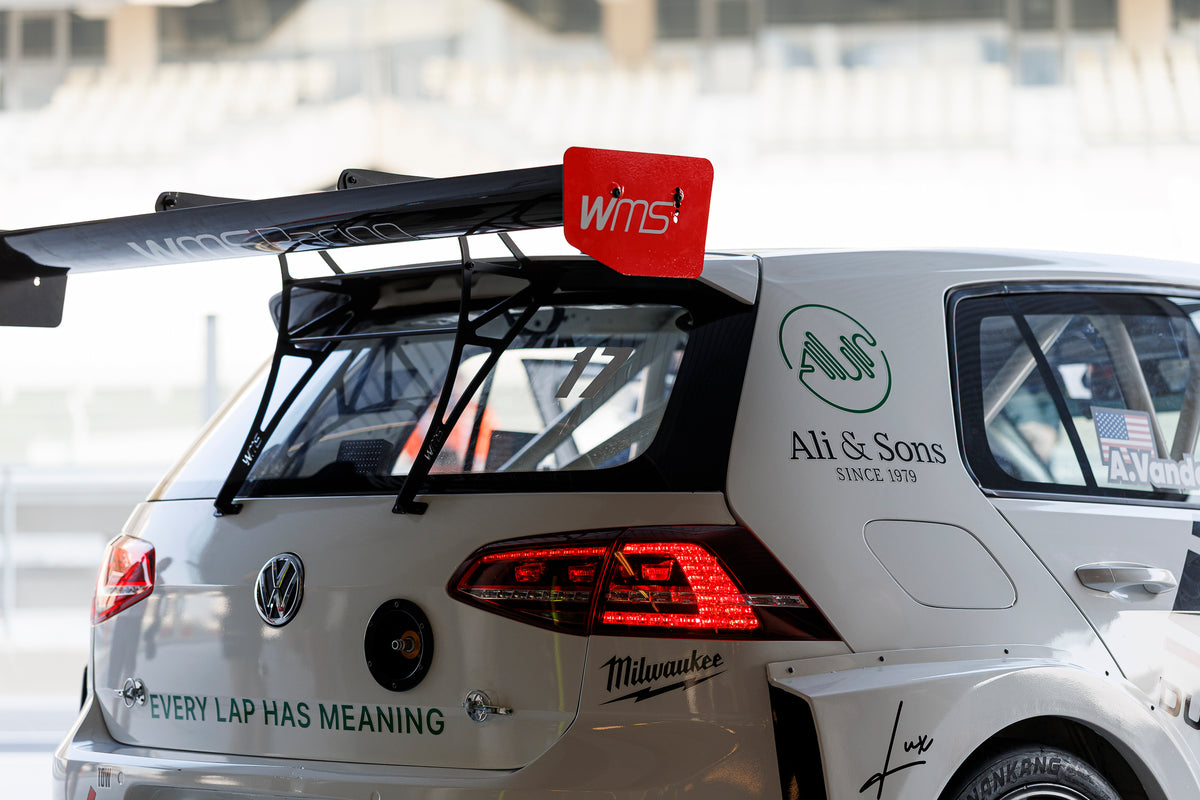 The rear of the Dutch Brothers Racing Golf with its wing, Ali and Sons branding and Every Lap Has Meaning across the tailgate.