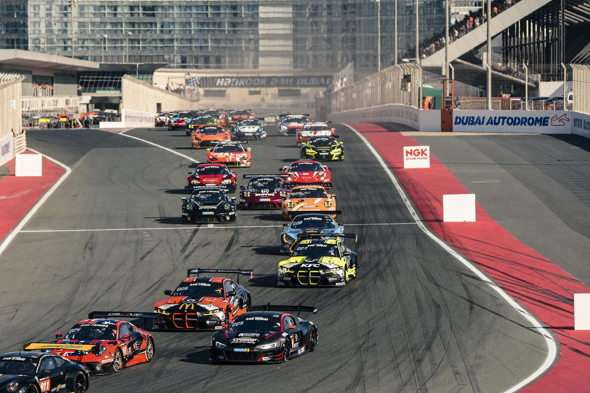 A packed GT field running through the opening corners at Dubai Autodrome.